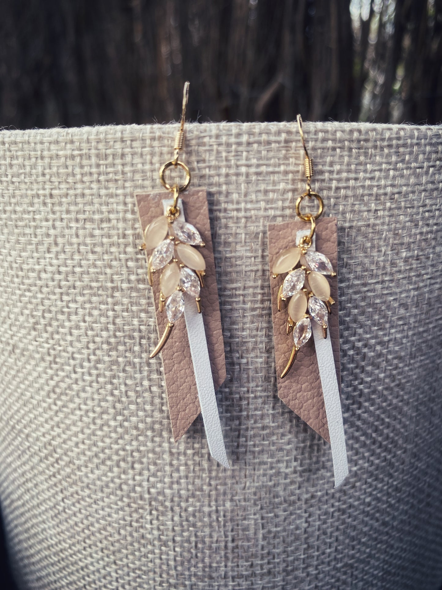 Auskari no dabīgās ādas un stikla kristāliem balti bēšos toņos, vienā eksemplārā. Apzeltīta furnitūra