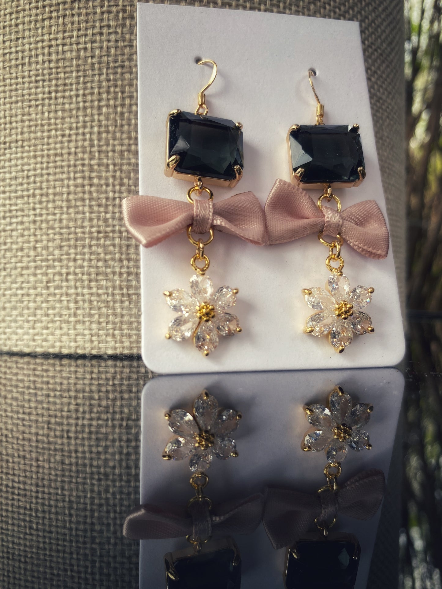 Auskari no stikla kristāliem melni ar rozā bantīti un baltu cirkoniju ziediņu. Apzeltīta furnitūra