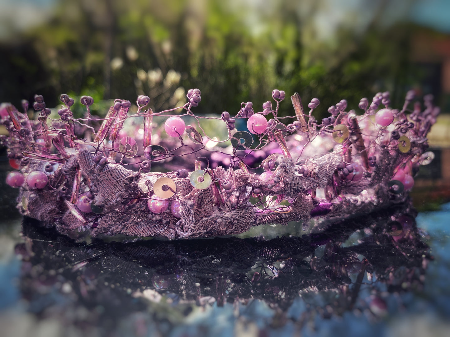 Pērļu kronis no dažāda lieluma violetām stikla un akrila pērlītēm.