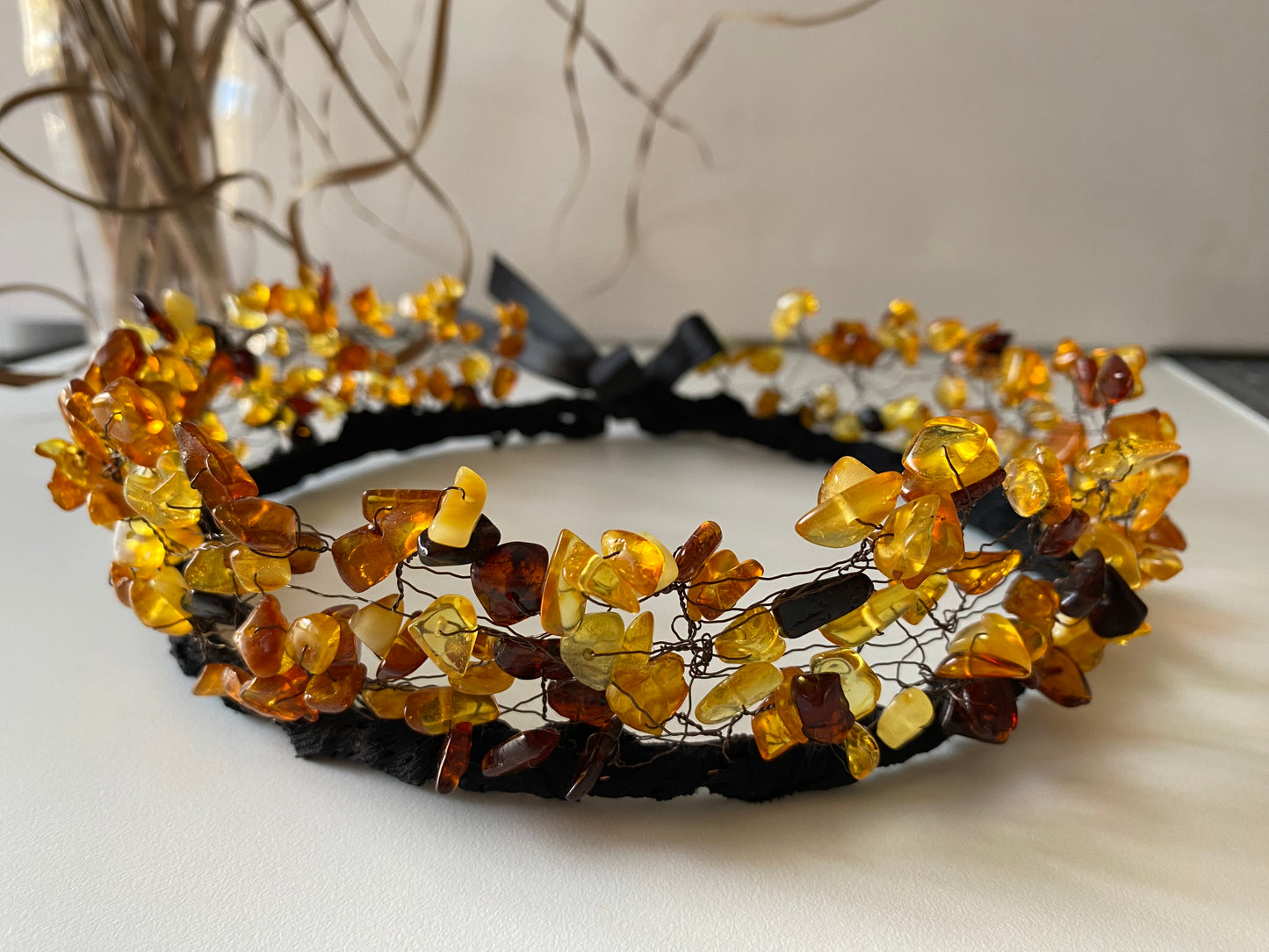 Stikla pērļu kronis no kopala (priežu sveķu) pērlēm. Dažādi oranži-brūnie, kā arī tumši brūnie toņi uz melnas pamatnes, sasienams