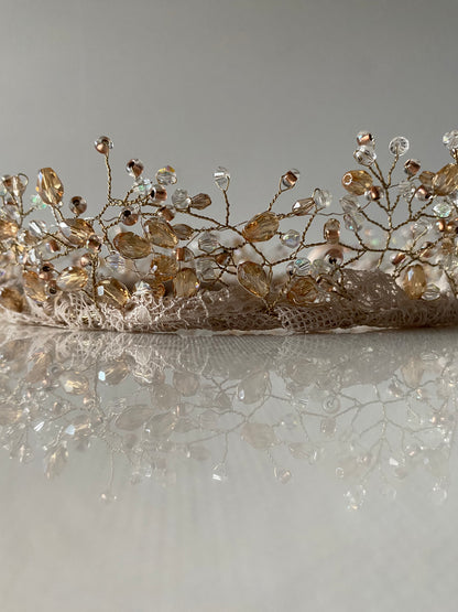 Stikla pērļu kronis baltos, bēšos un caurspīdīgos toņos ar mežģīnes apdares pamatni bēšā krāsā, sasienams