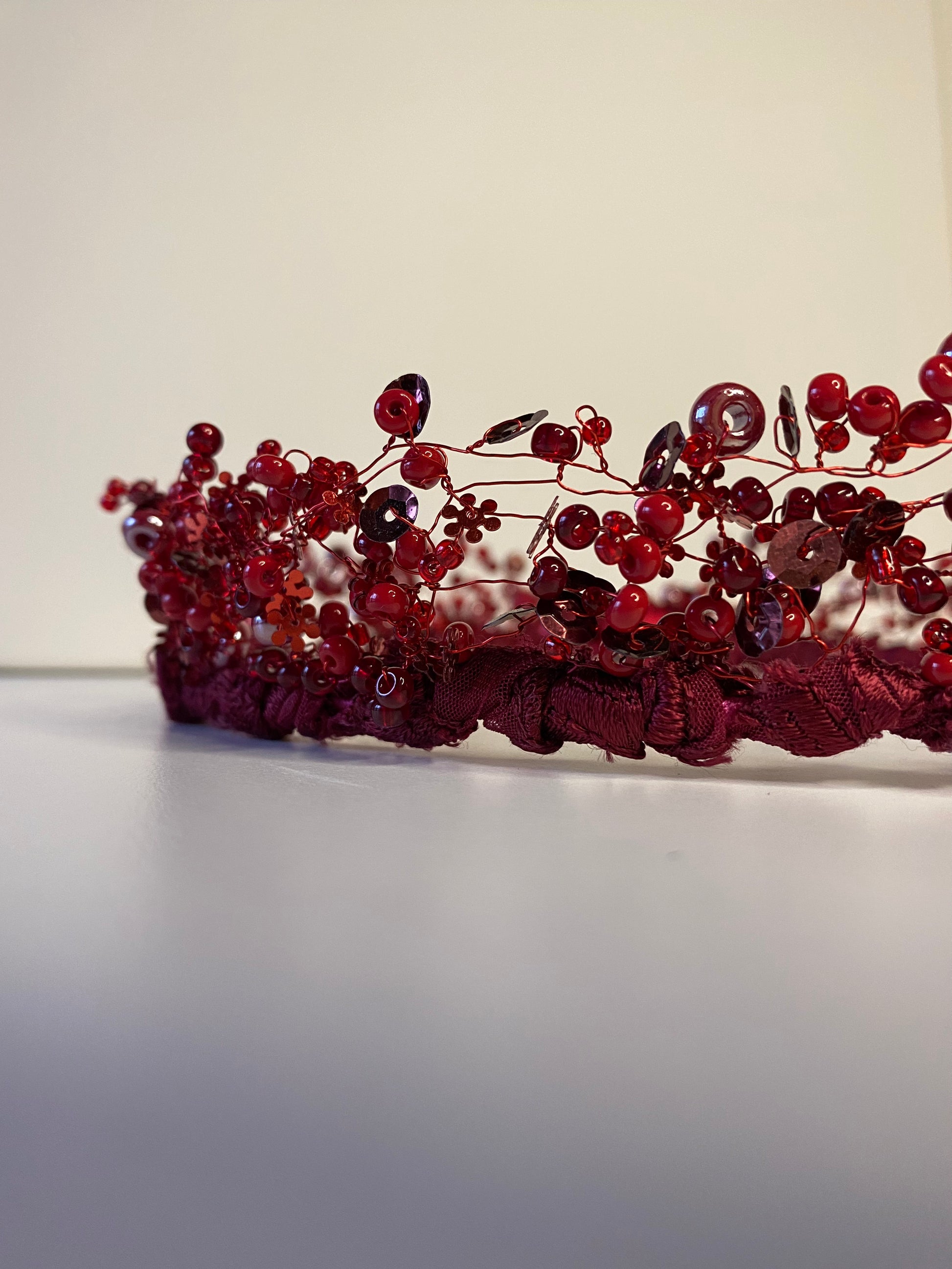 Pērļu kronis no dažāda lieluma sarkanām stikla un akrila pērlītēm.