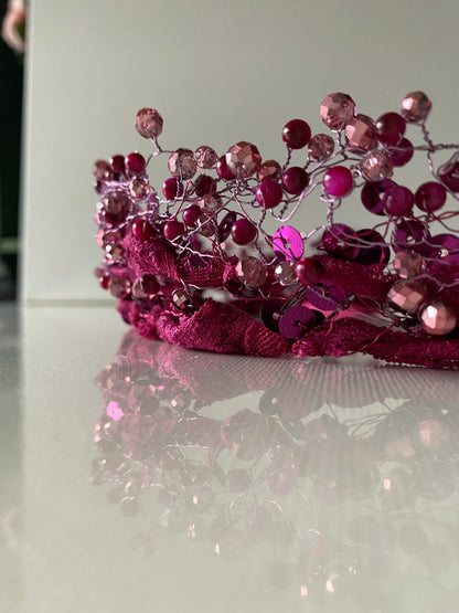 Stikla un akrila pērļu kronis tumšos un gaišos rozā toņos uz mežģīnes apdares pamatnes, sasienams