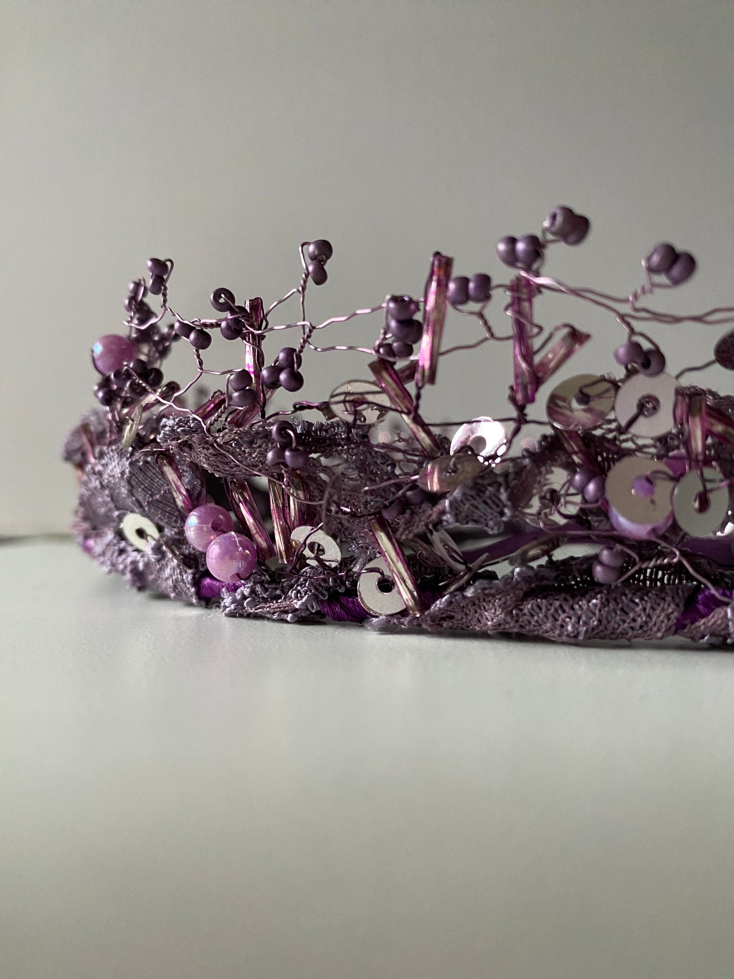 Pērļu kronis no dažāda lieluma violetām stikla un akrila pērlītēm.