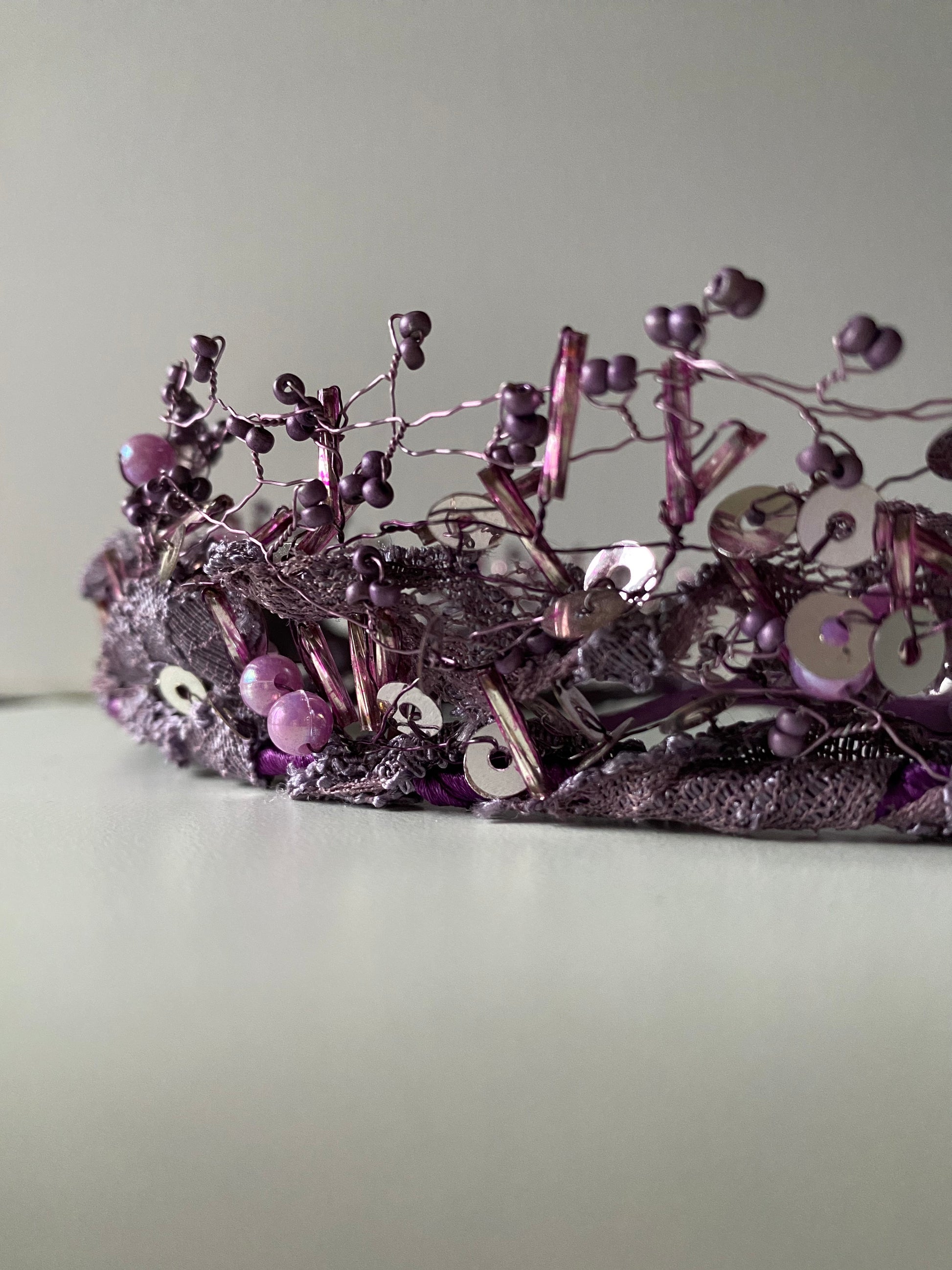 Pērļu kronis no dažāda lieluma violetām stikla un akrila pērlītēm.