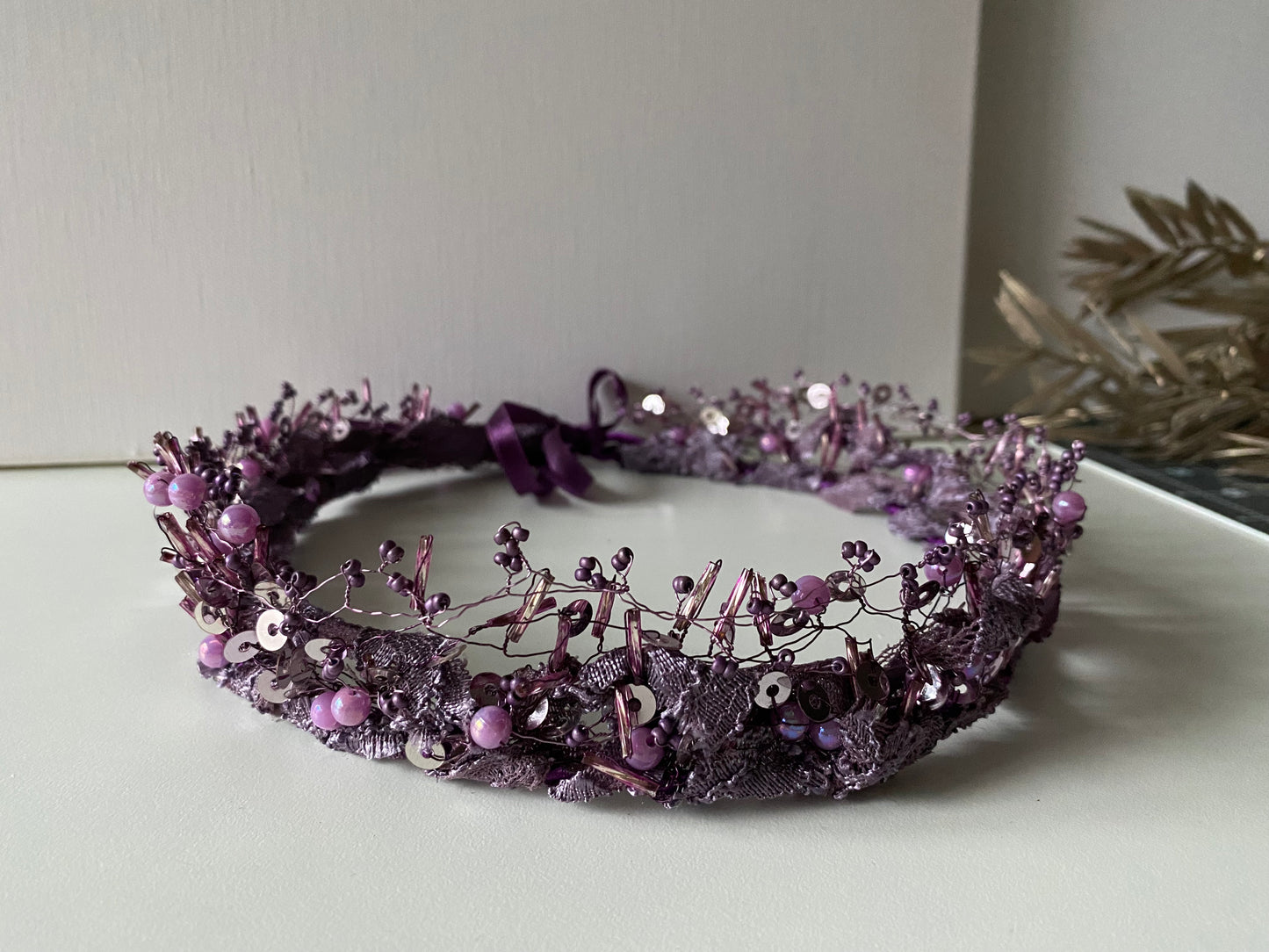 Pērļu kronis no dažāda lieluma violetām stikla un akrila pērlītēm.