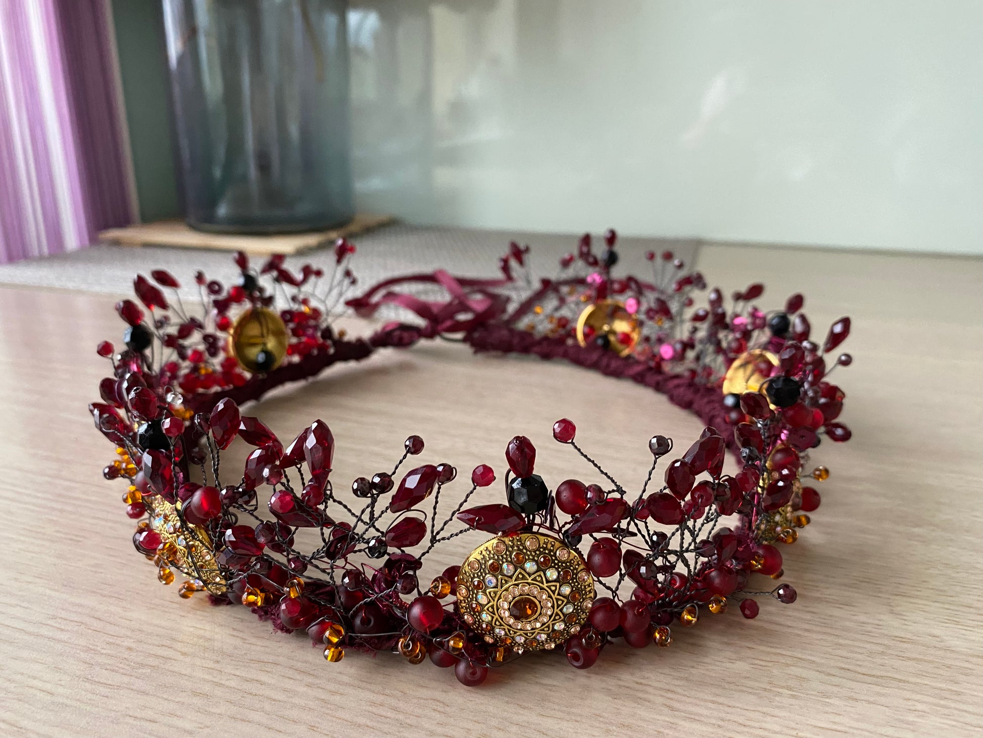 Stikla kristālu un pērļu kronis, tumši sarkans ar metāla detaļām un mežģīnes pamatnes apdari