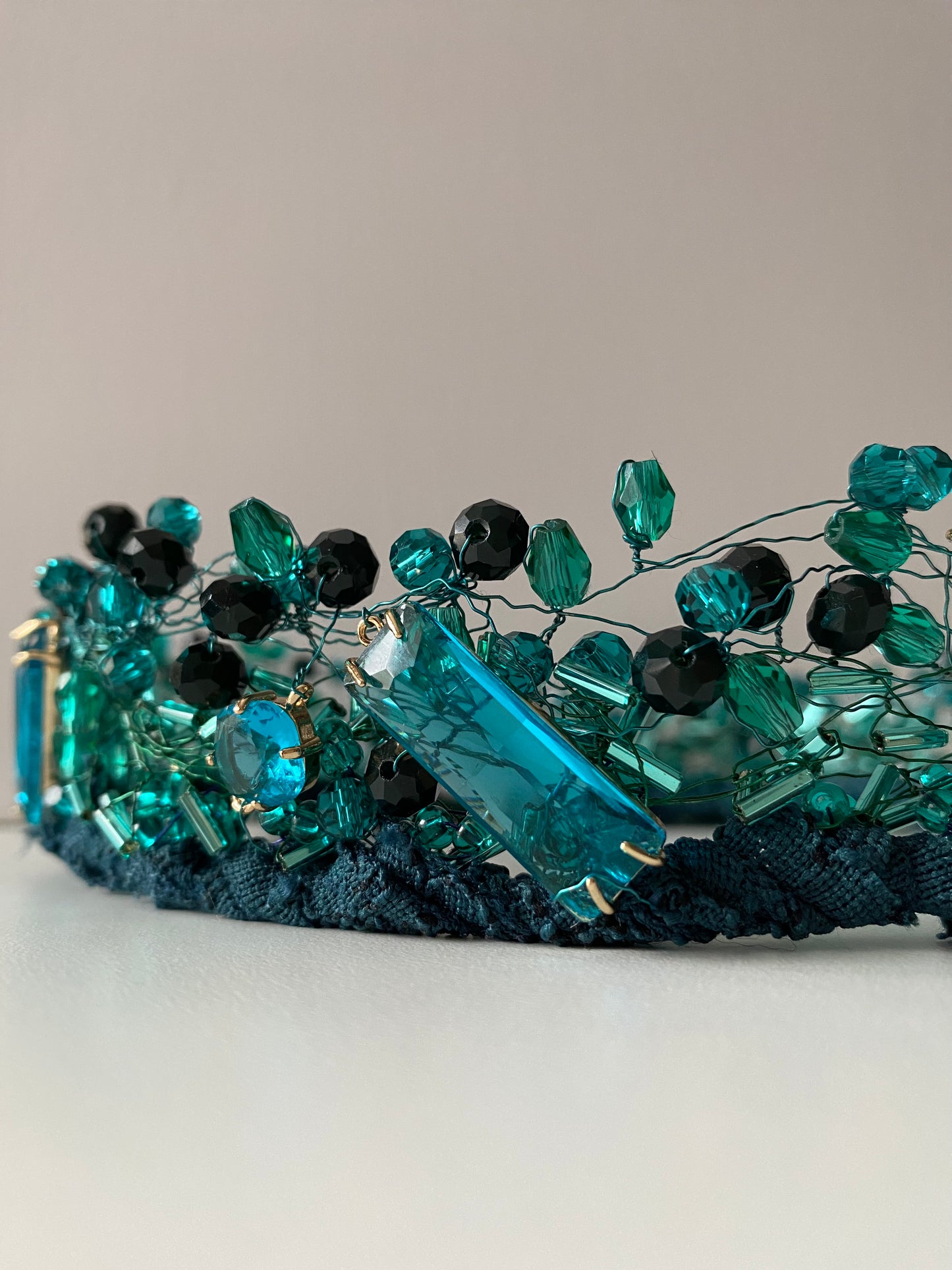 Stikla pērļu kronis no dažāda lieluma stikla pērlēm un kristāliem zilizaļš