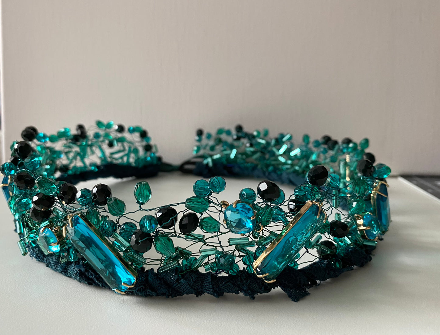 Stikla pērļu kronis no dažāda lieluma stikla pērlēm un kristāliem zilizaļš