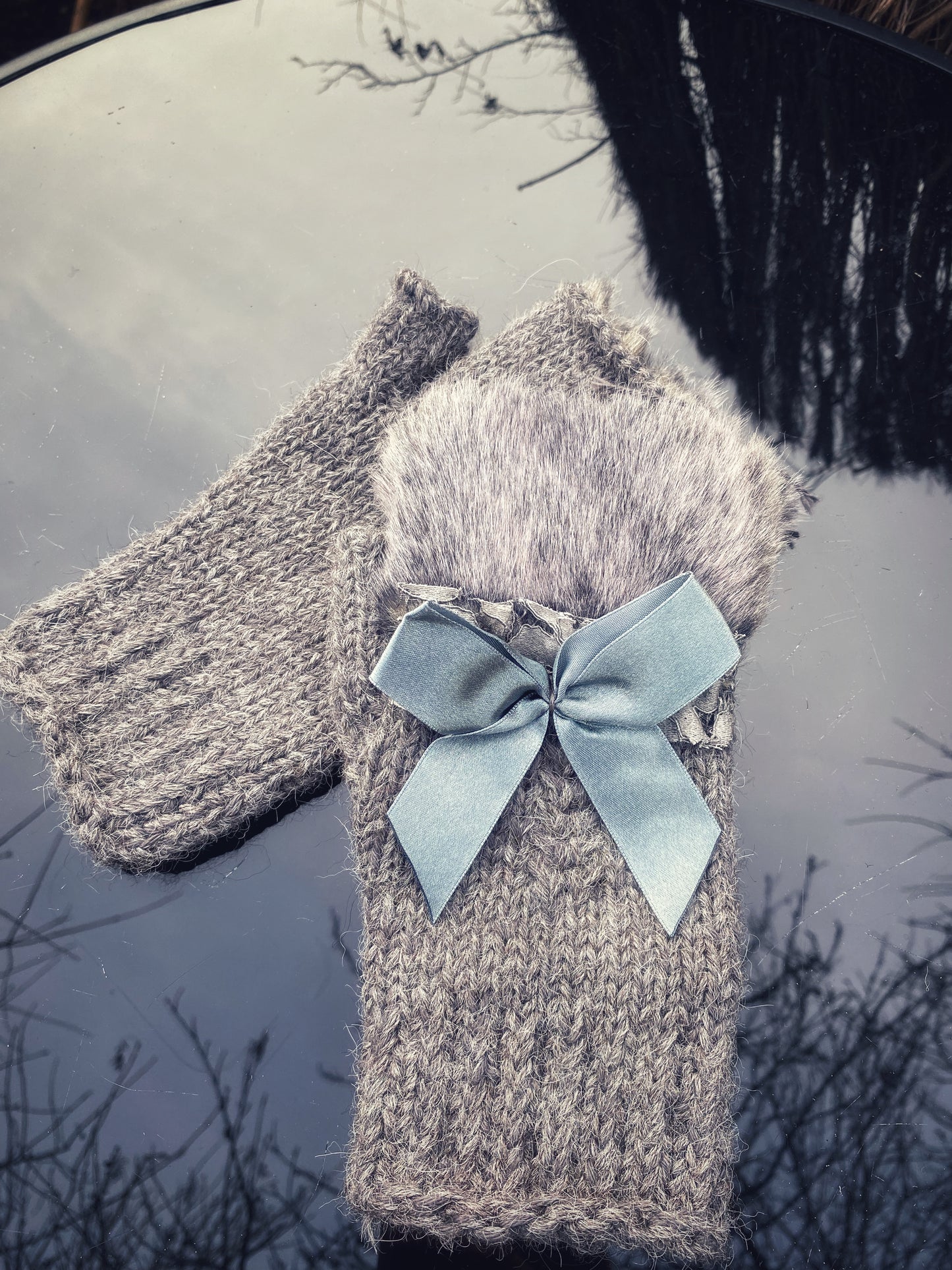 Pieaugušo puscimdiņi ar anatomisko īkšķi, no pelēkas alpakas dzijas ar mākslīgās kažokādas dekoru un atlasa banti